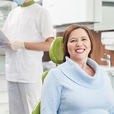 Woman in dental chair for implant-retained dentures