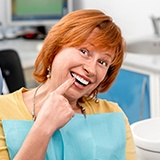 Senior woman pointing to new denture