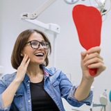 young woman admiring her new dental implants in La Porte