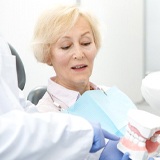 dentist in La Porte showing dentures to a patient