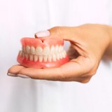 dentist holding a set of full dentures