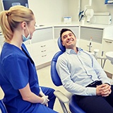 man in blue dress shirt smiling in dental chair