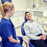 man in blue dress shirt smiling in dental chair