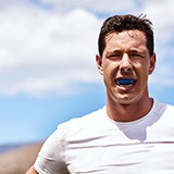 Man wears athletic mouthguard