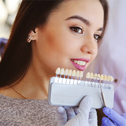 A woman covering her mouth at the dentist.