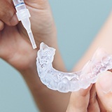 Patient using a take-home teeth whitening kit