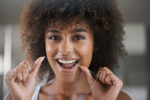 woman flossing smiling 