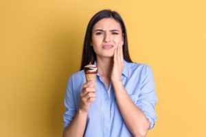 woman with sensitive teeth eating ice cream 