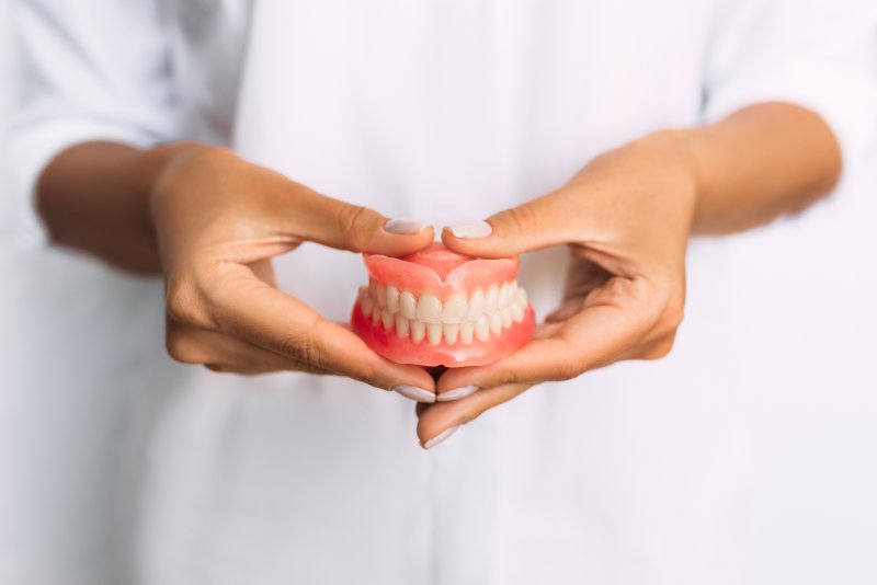 dentist holding dentures in hands