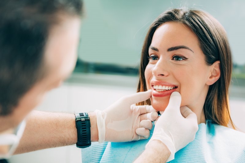 A dentist helping a woman with non-invasive cosmetic dentistry